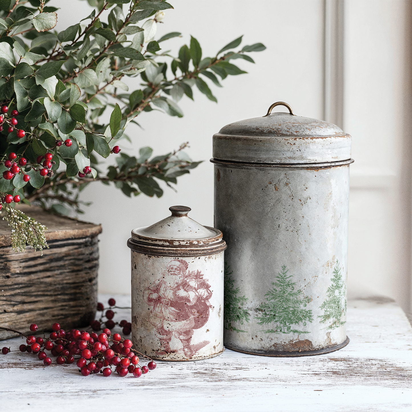 "Christmas Wishes" IOD Stamp by Iron Orchid Designs. Single sheet stamp. Available at Milton's Daughter. Example pic. Two vintage-style metal canisters with decorative lids on a wooden surface with greenery and berries.