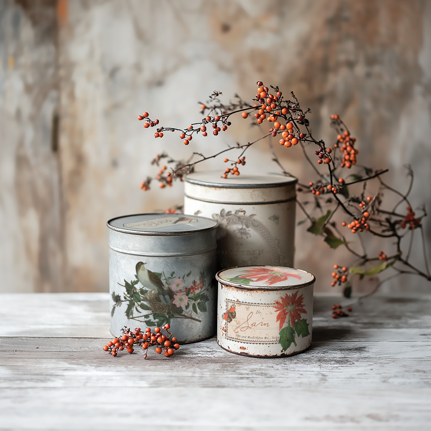 "Winter Botanist" IOD Transfer by Iron Orchid Designs. Example Pic 2. Transfer available at Milton's Daughter. Decorative tin containers with floral designs on a wooden surface with berries.