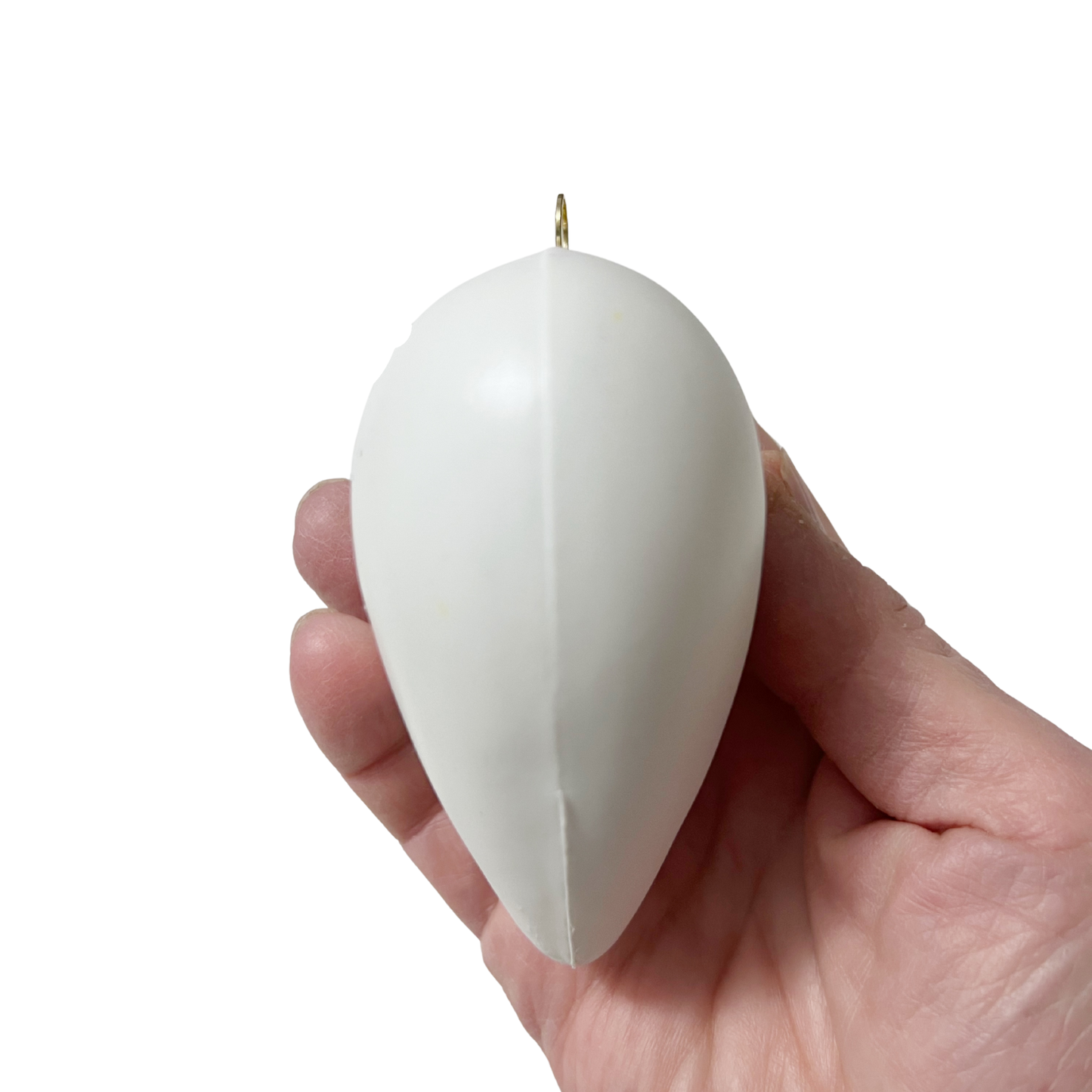 White puffed heart shaped ornament, side view, held in a hand against a white background