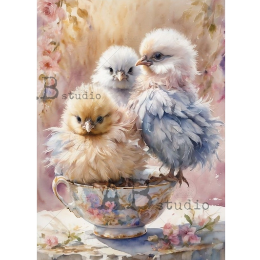 Three fluffy chicks in a decorative teacup with a soft, pastel background.
