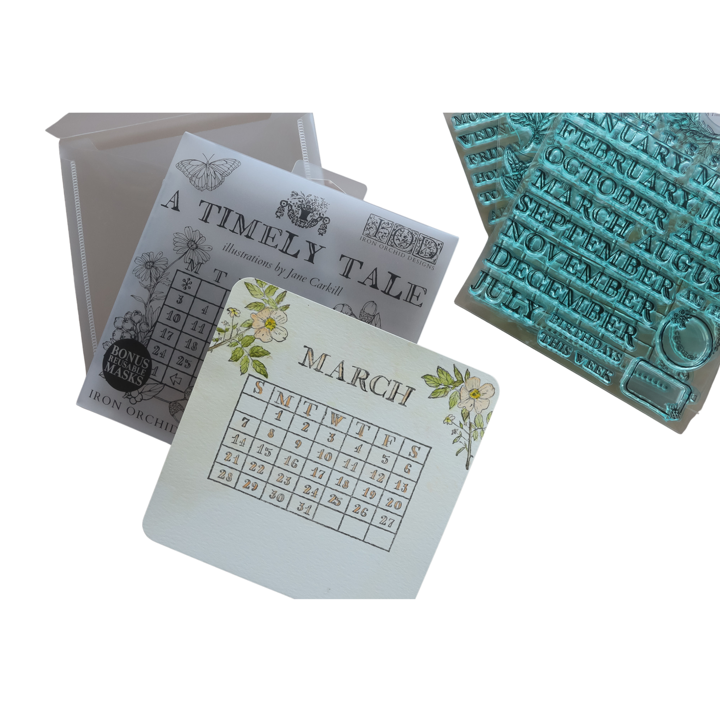 A Timely Tale IOD Mini Stamp Boxed Set by Iron Orchid Designs, featuring a March calendar card with floral accents, a sheet of stamped month names, all displayed on a white background.