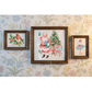 Three framed vintage-style framed holiday themed images made with IOD transfers displayed on a floral wallpaper background. The central, largest framed piece depicts Santa Claus with a Christmas tree and gifts, flanked by two smaller framed pieces showing a red bird and a ballerina.