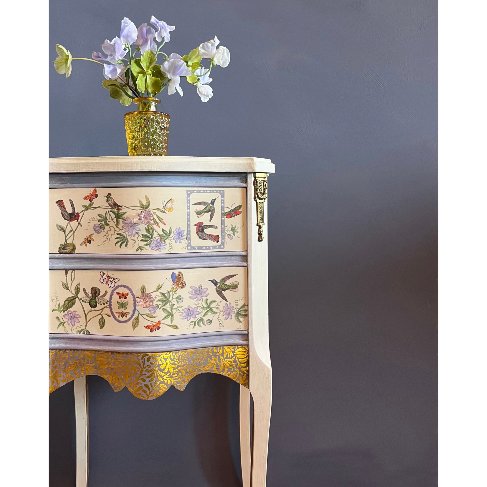 Decorative side table with floral patterns against a dark gray background