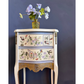 Decorative side table with floral and bird patterns on a dark background