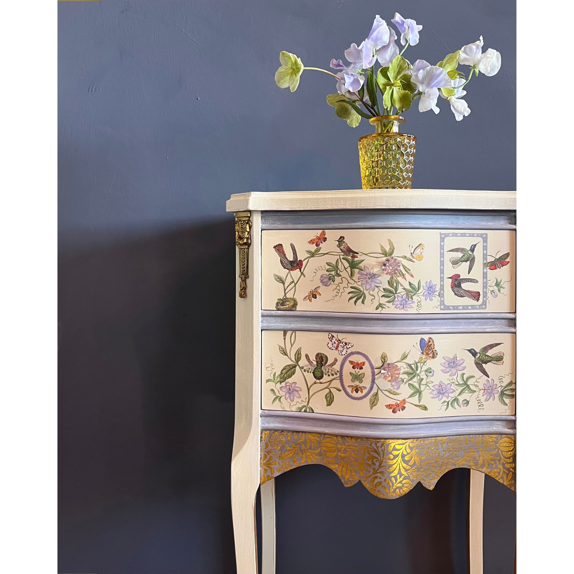 Decorative chest of drawers with floral and bird patterns on a dark background