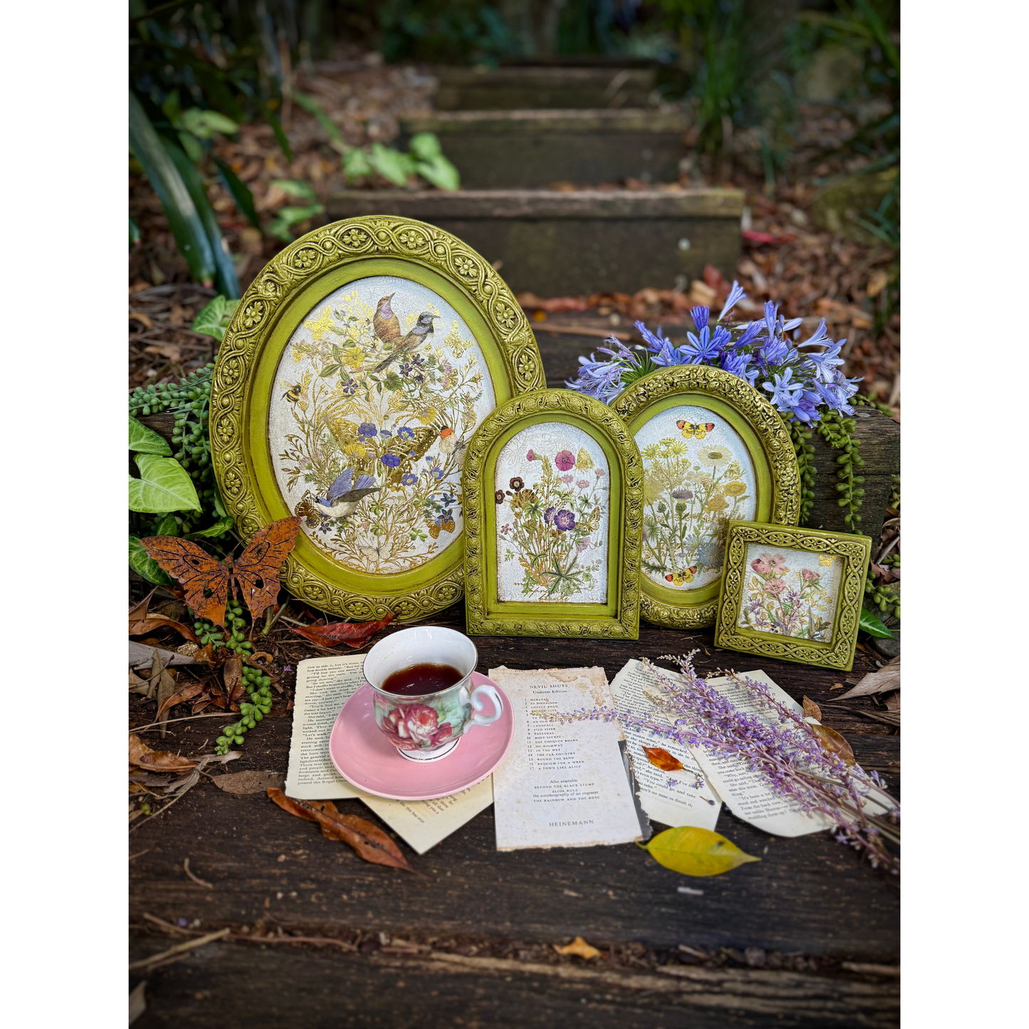 Decorative frames with floral designs on a natural setting with a cup and saucer.