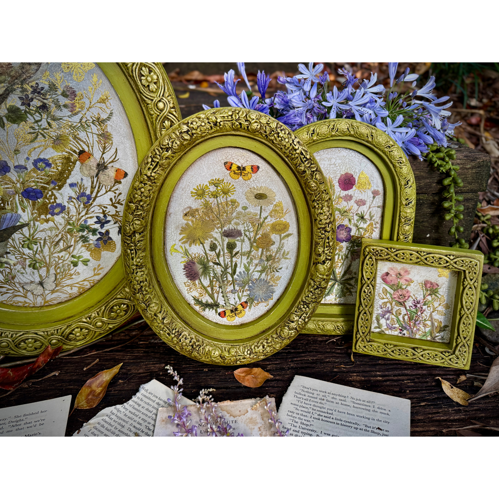 Decorative frames with floral designs on a wooden surface with flowers in the background