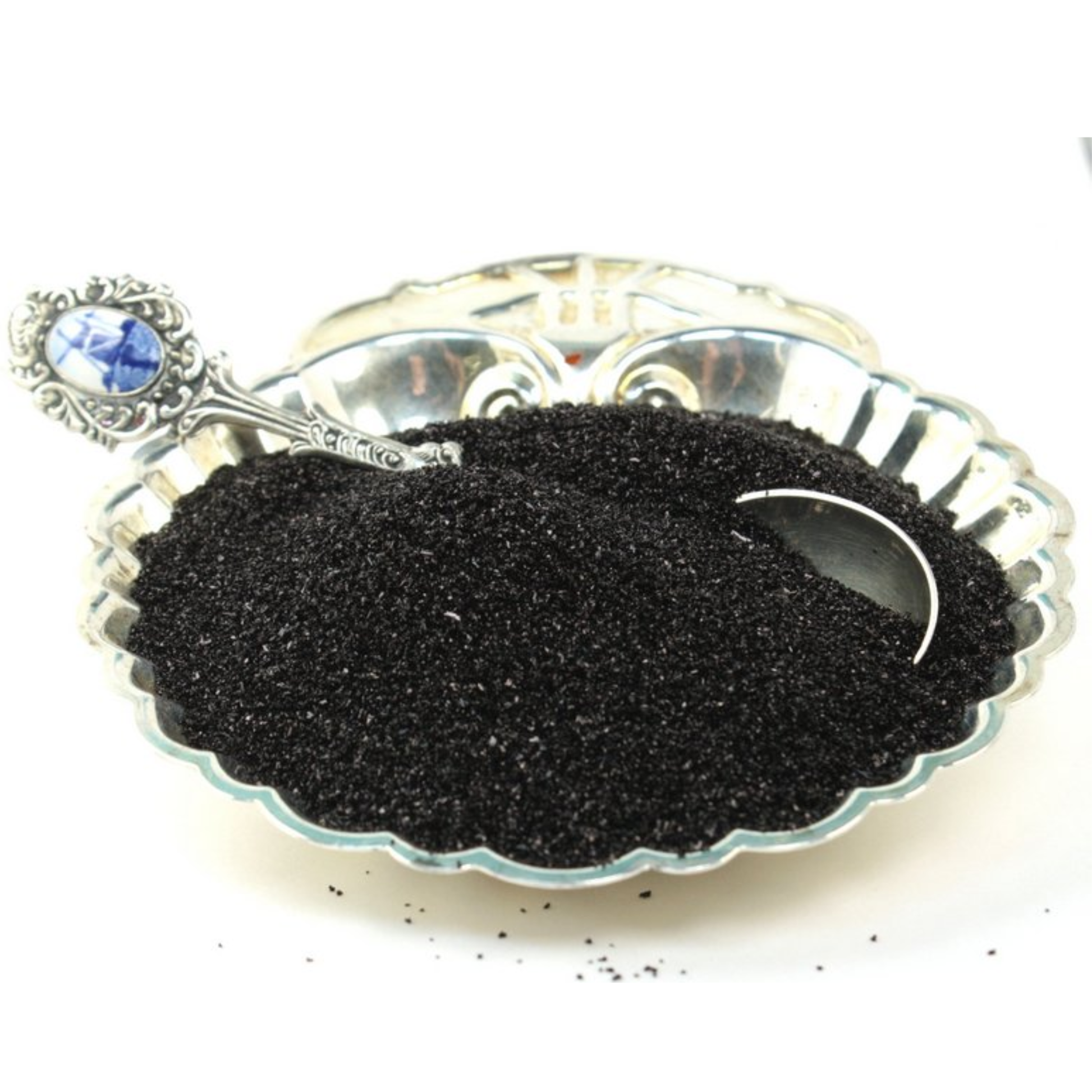 Silver spoon with black glitter on a white background