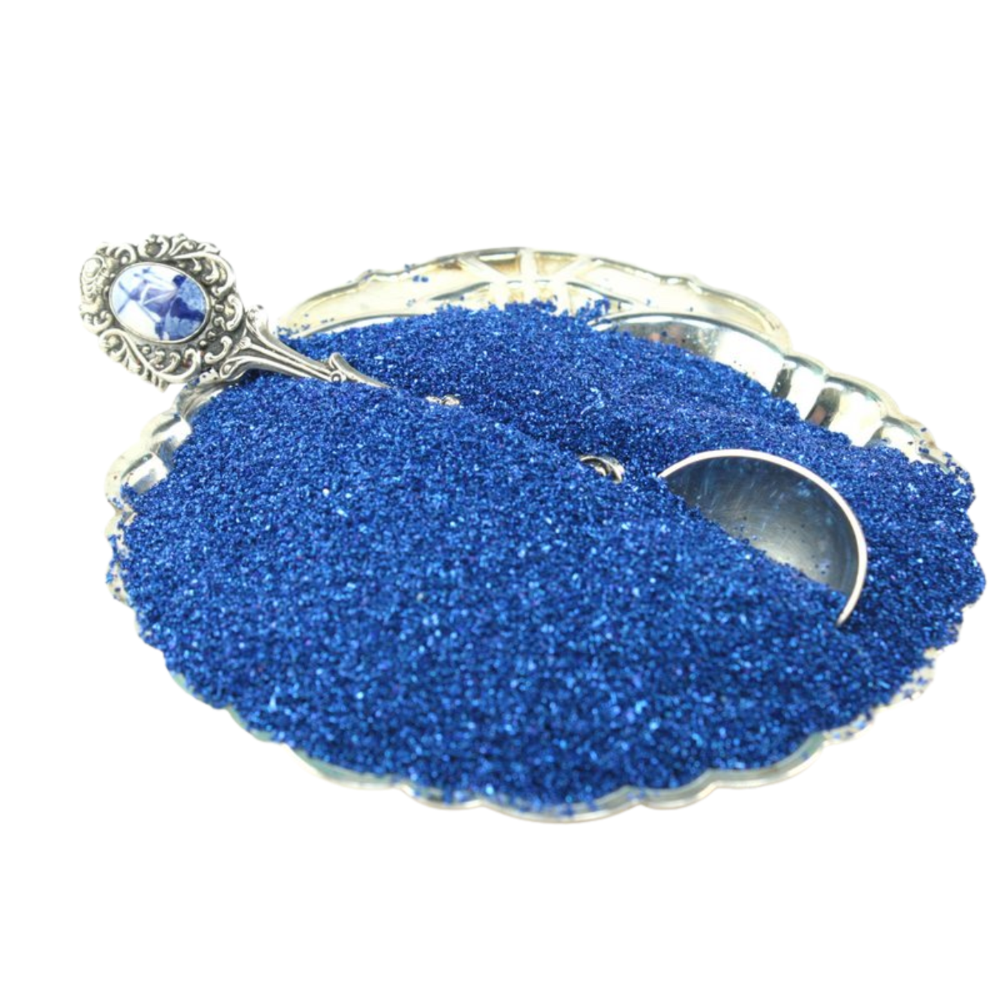 Blue glitter in a decorative dish with a spoon on a white background