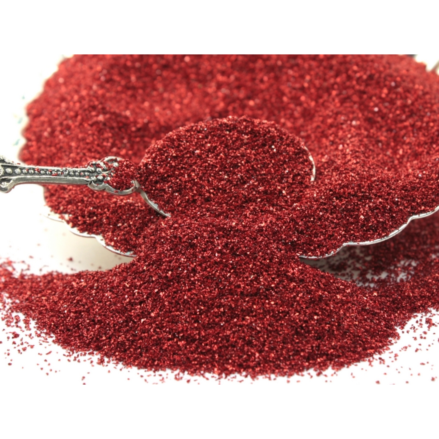 Red glitter with a spoon on a white background
