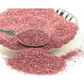 Pink glitter on a silver plate with a silver spoon
