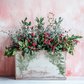 "Holly & Pine IOD Stamp by Iron Orchid Designs. Single sheet stamp. Available at Milton's Daughter. Example pic. Decorative floral arrangement with greenery and red berries in a wooden box against a pink textured background.