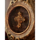 Decorative cross inside an ornate wooden frame