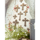 Decorative wall hanging with crosses and floral elements on a white background