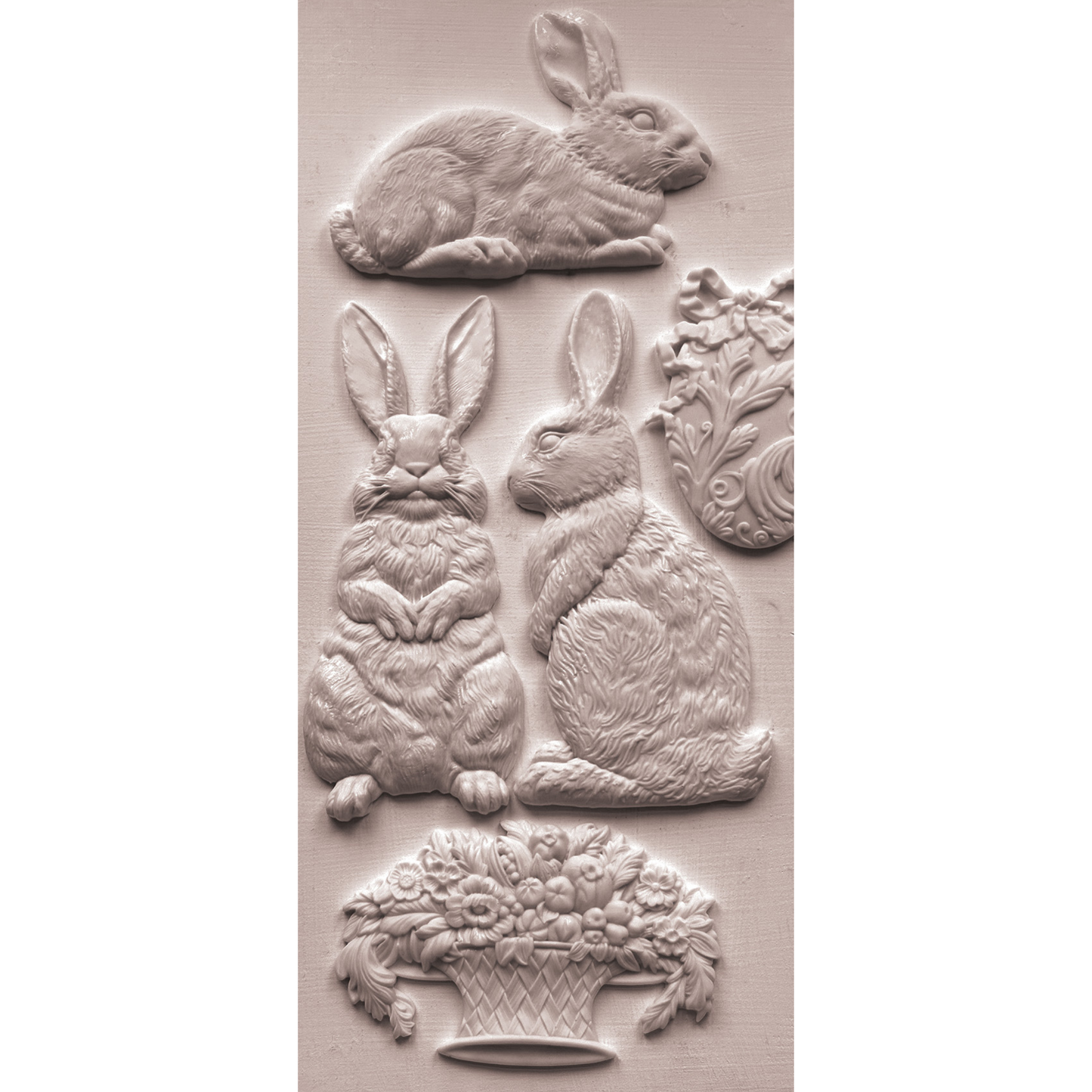 Silicone mold castings with rabbits, eater egg and basket of flowers on a beige background