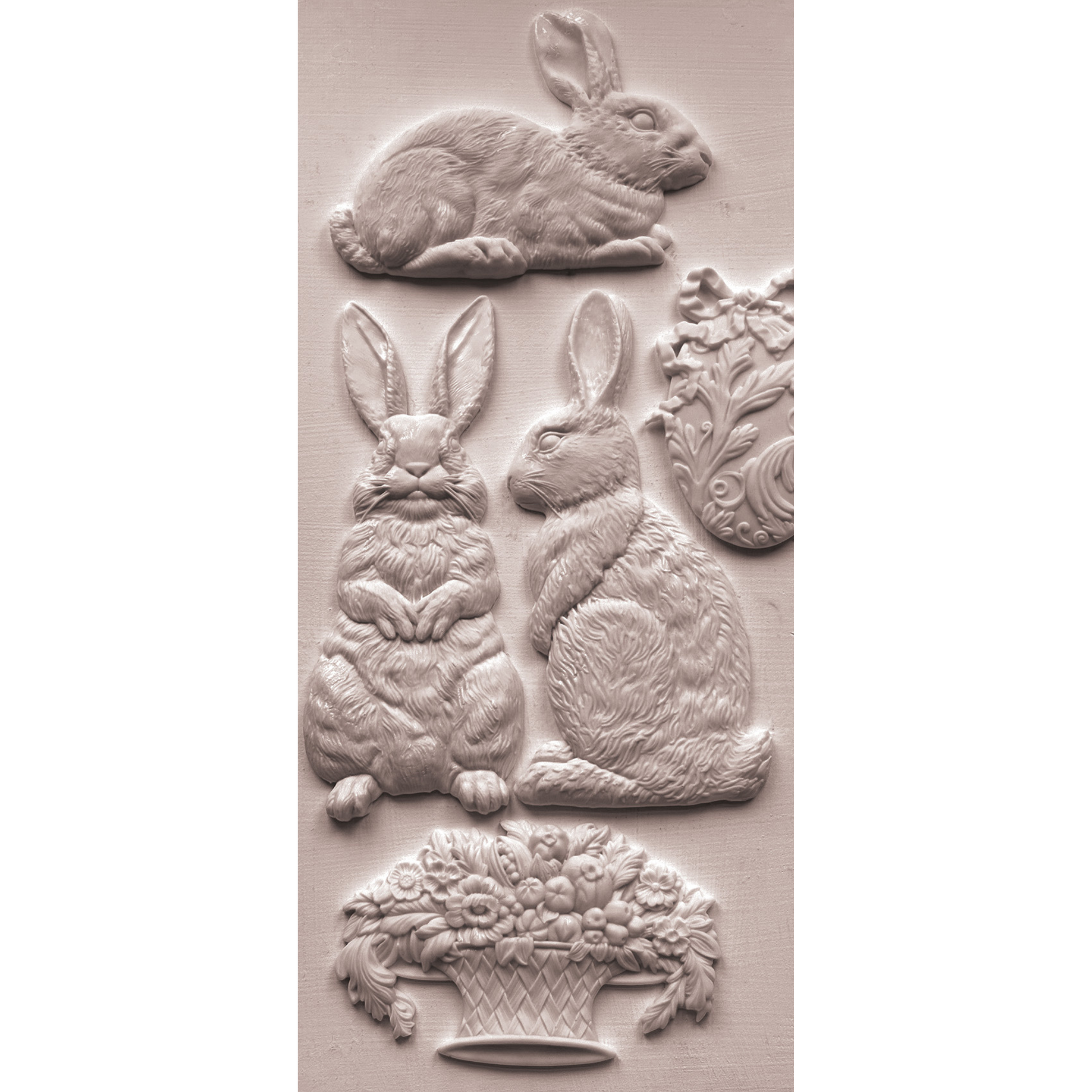 Silicone mold castings with rabbits, eater egg and basket of flowers on a beige background