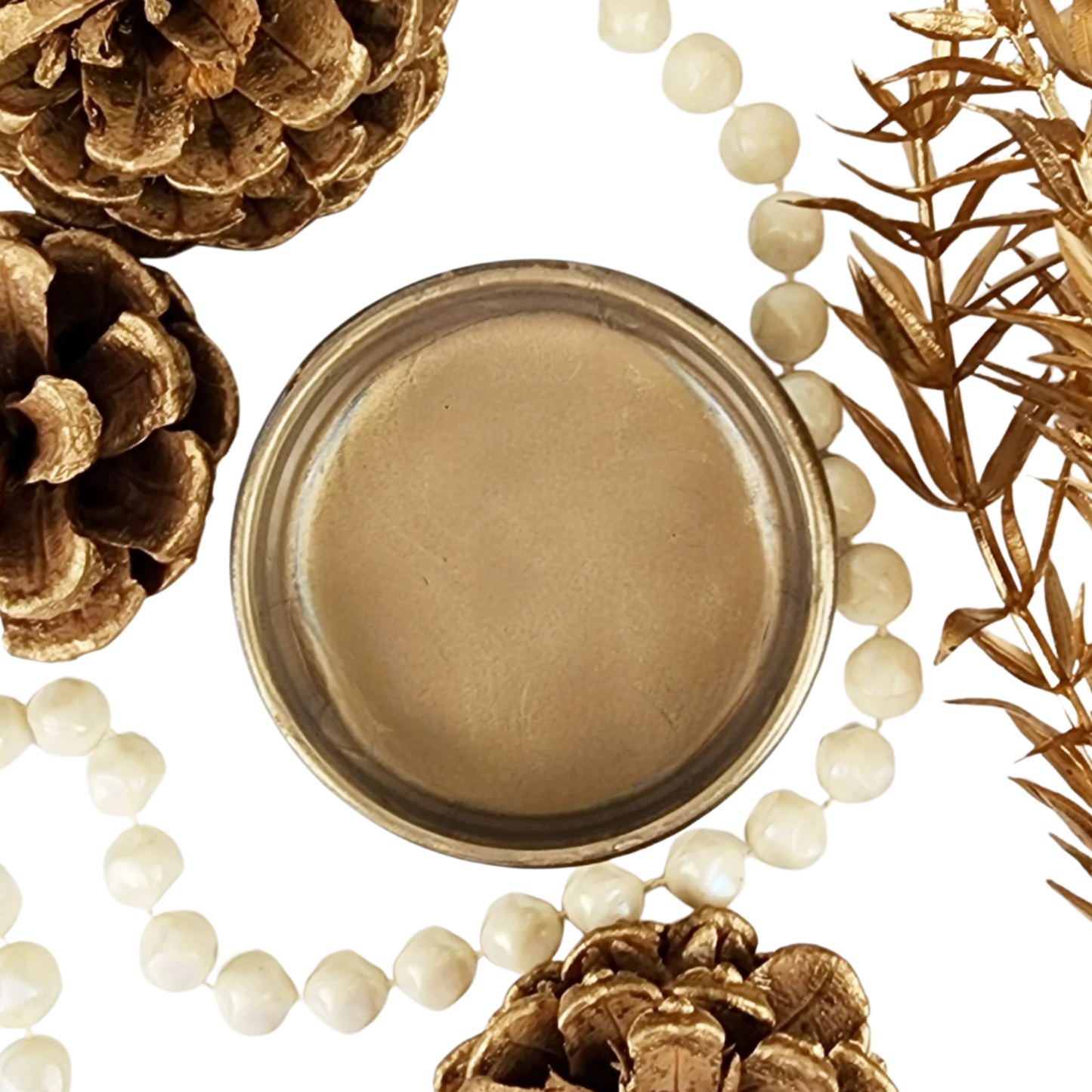 Close-up of a pot of bronze metallic paint surrounded by pinecones and beads on a white background