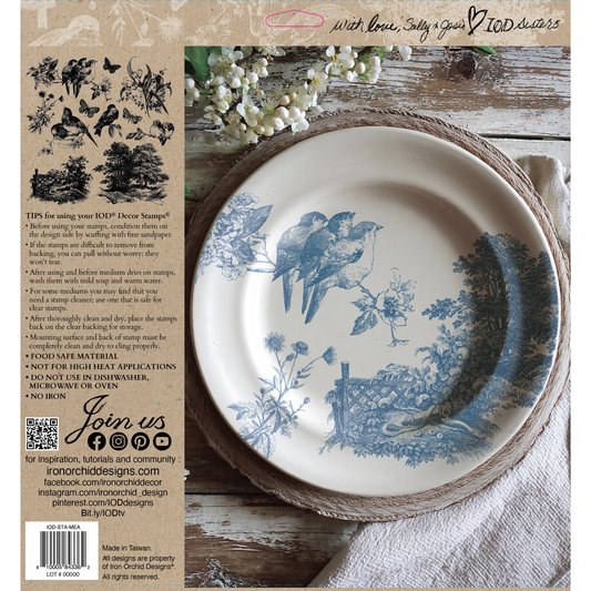 Meadowlark back cover. Decorative plate with blue bird design on a wooden stand, surrounded by nature-themed elements from the Meadowlark IOD Stamp.