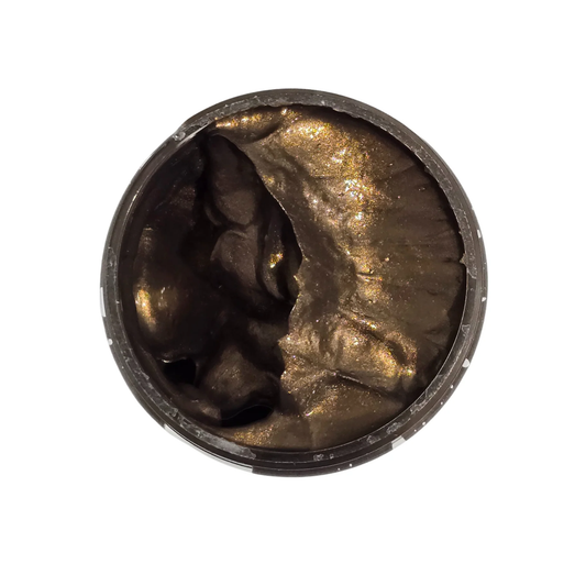 Bronze colored paste in a jar on a white background.