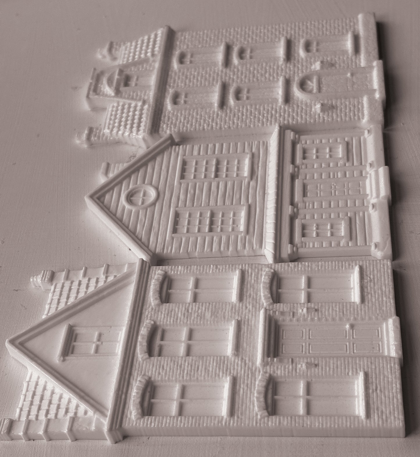 IOD Mould Old Colchester Road castings, featuring  detailed house designs with windows, doors, and textured brick patterns, arranged on a light gray background.