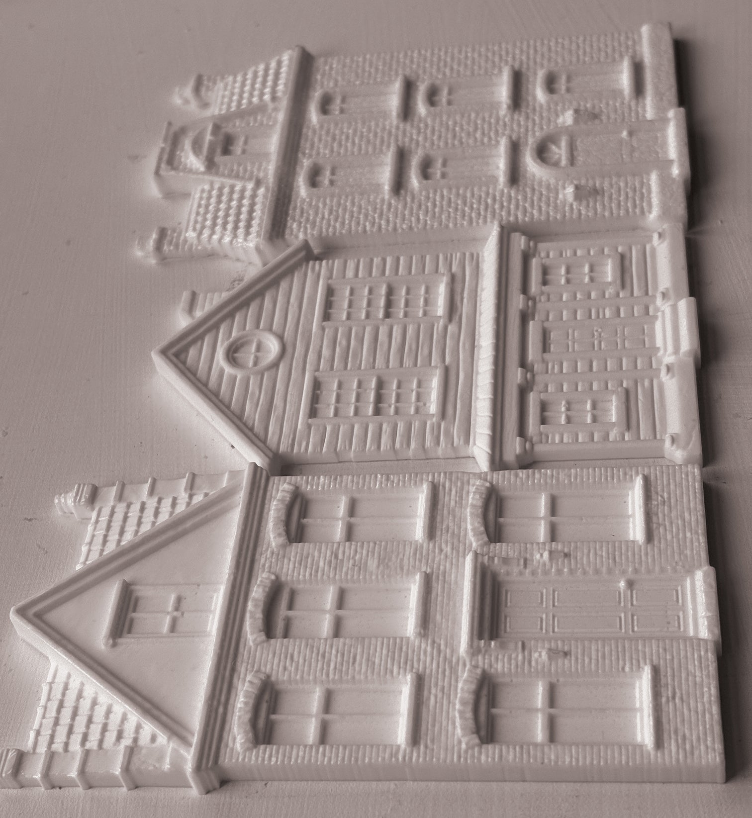 IOD Mould Old Colchester Road castings, featuring  detailed house designs with windows, doors, and textured brick patterns, arranged on a light gray background.