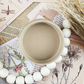 Image of open jar of beige paint on background of sepia printed ephemera with text and wheat sprigs.