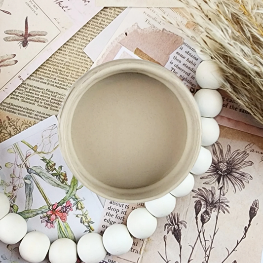 Image of open jar of beige paint on background of sepia printed ephemera with text and wheat sprigs.