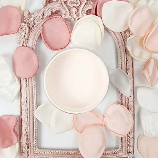 Image of pale pink open jar of paint with pink rose petals and a vintage frame.