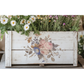 Decorative wooden planter with floral design and plants on a white background