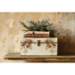 "Santa's Hollow" IOD Transfer by Iron Orchid Designs. Example Pic 1. Transfer  available at Milton's Daughter. Decorative box with floral patterns and greenery on a wooden surface against a beige wall.