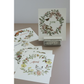 A set of monthly cards displayed on a tabletop, with one card standing upright on a small stand and several cards fanned out below. The cards feature watercolor floral wreaths and seasonal IOD transfer images, including a chicken for April and a fox for January.