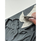 Person using a tool to shape a piece of clay on a mold with IOD "Tulips' branding.
