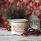 "Twelfth Night" IOD Paint Inlay by Iron Orchid Designs. Example pic 3. Transfer available at Milton's Daughter. Decorative ceramic container with 'Merry' text, surrounded by red berries and greenery on a wooden surface.