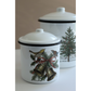 Two white enamel canisters with lids, decorated with IOD transfers. The front canister features gold bells, holly leaves, pine branches, and birds with a red ribbon.
