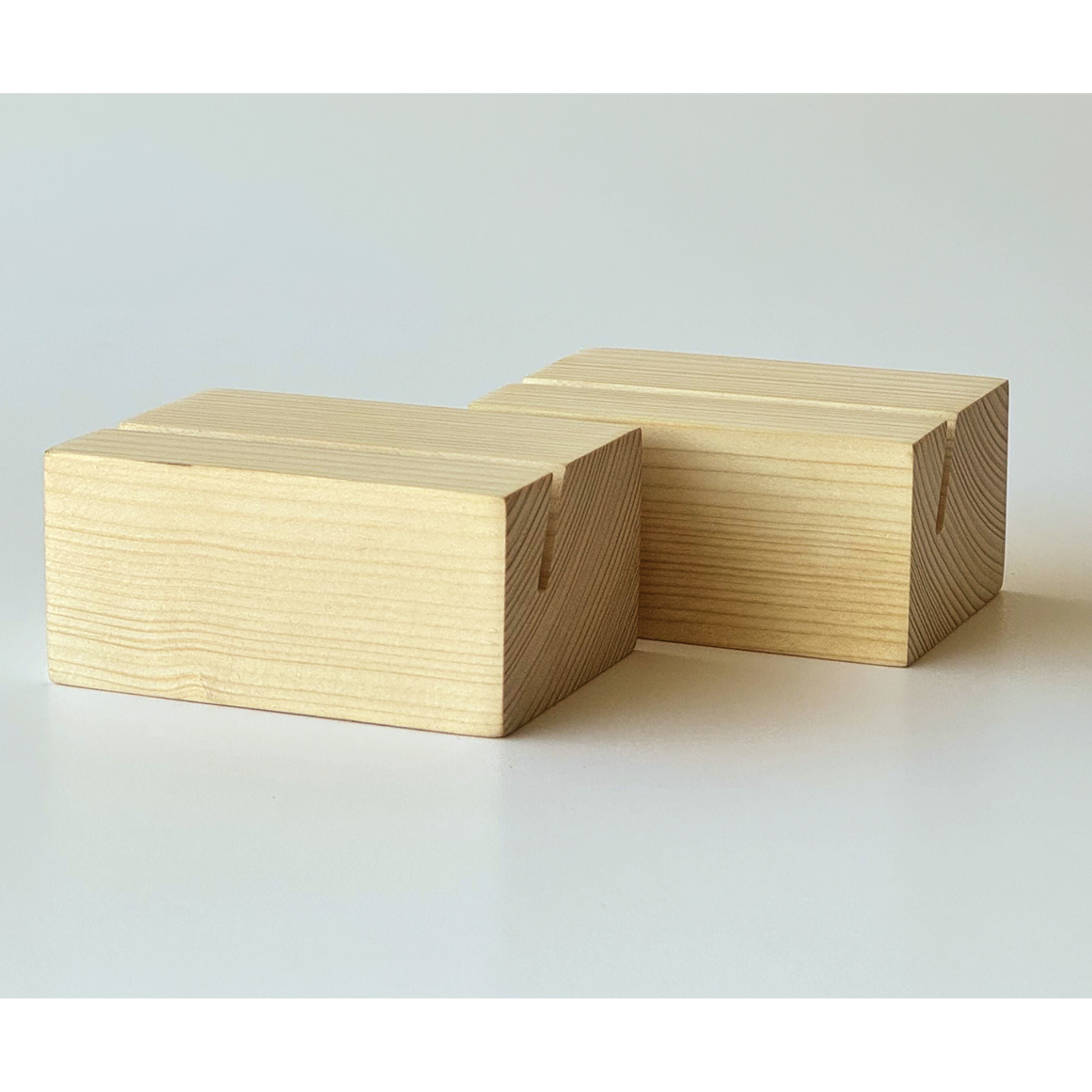 Two rectangular wooden blocks with visible wood grain and a small notch on one side, photographed on a clean light gray studio background.