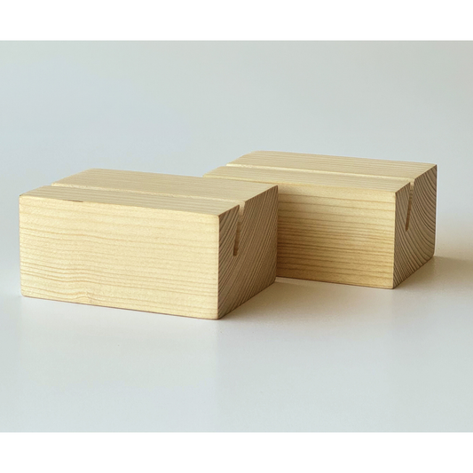 Two rectangular wooden blocks with visible wood grain and a small notch on one side, photographed on a clean light gray studio background.