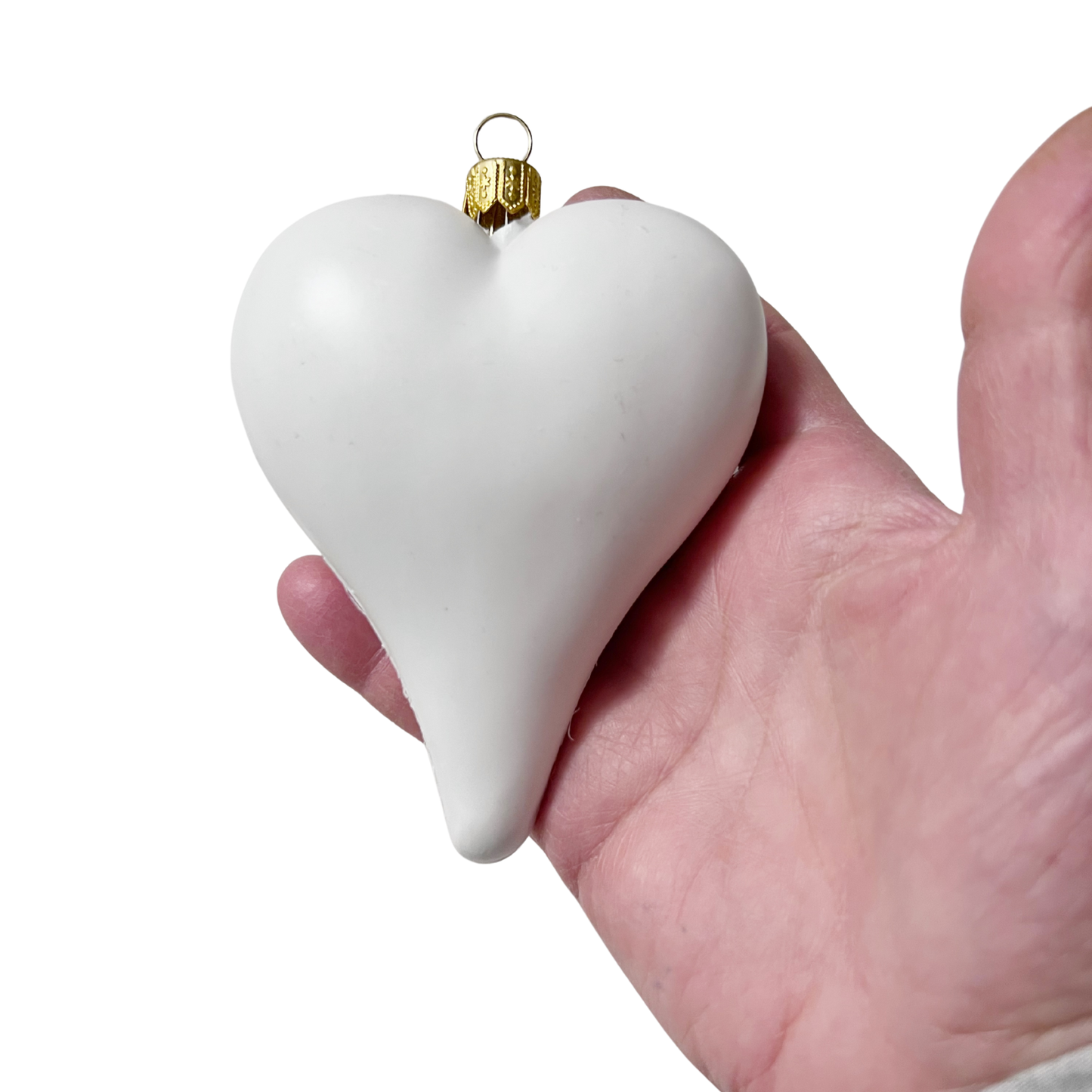 White heart-shaped ornament held in a hand against a white background