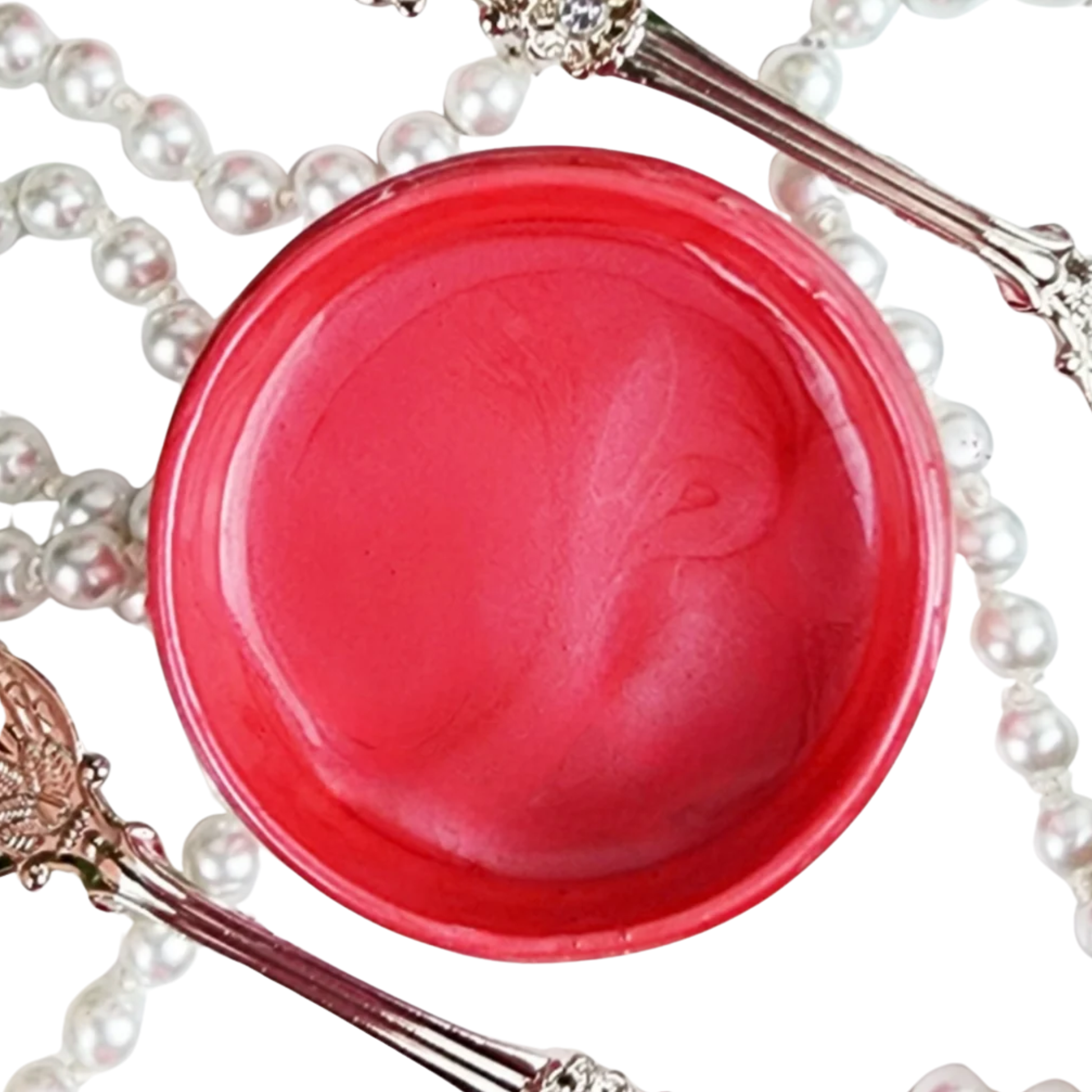 Pot of deep pink metallic paint with a pearl necklace and decorative items on a white background