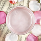 Jar of pink metallic paint surrounded by pink and white flowers on sheet music background