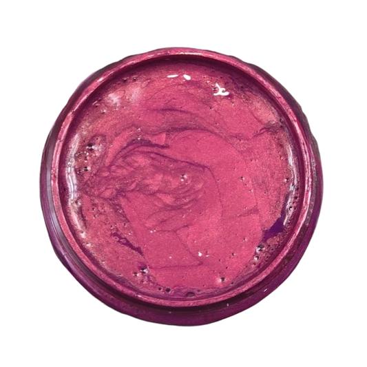 Open jar of deep pink metallic paint on a white background.