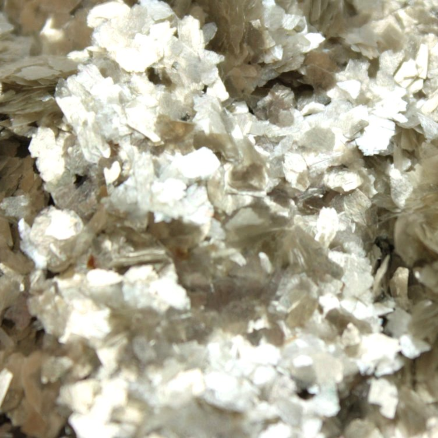 Close-up of a textured beige metallic surface with small mica particles