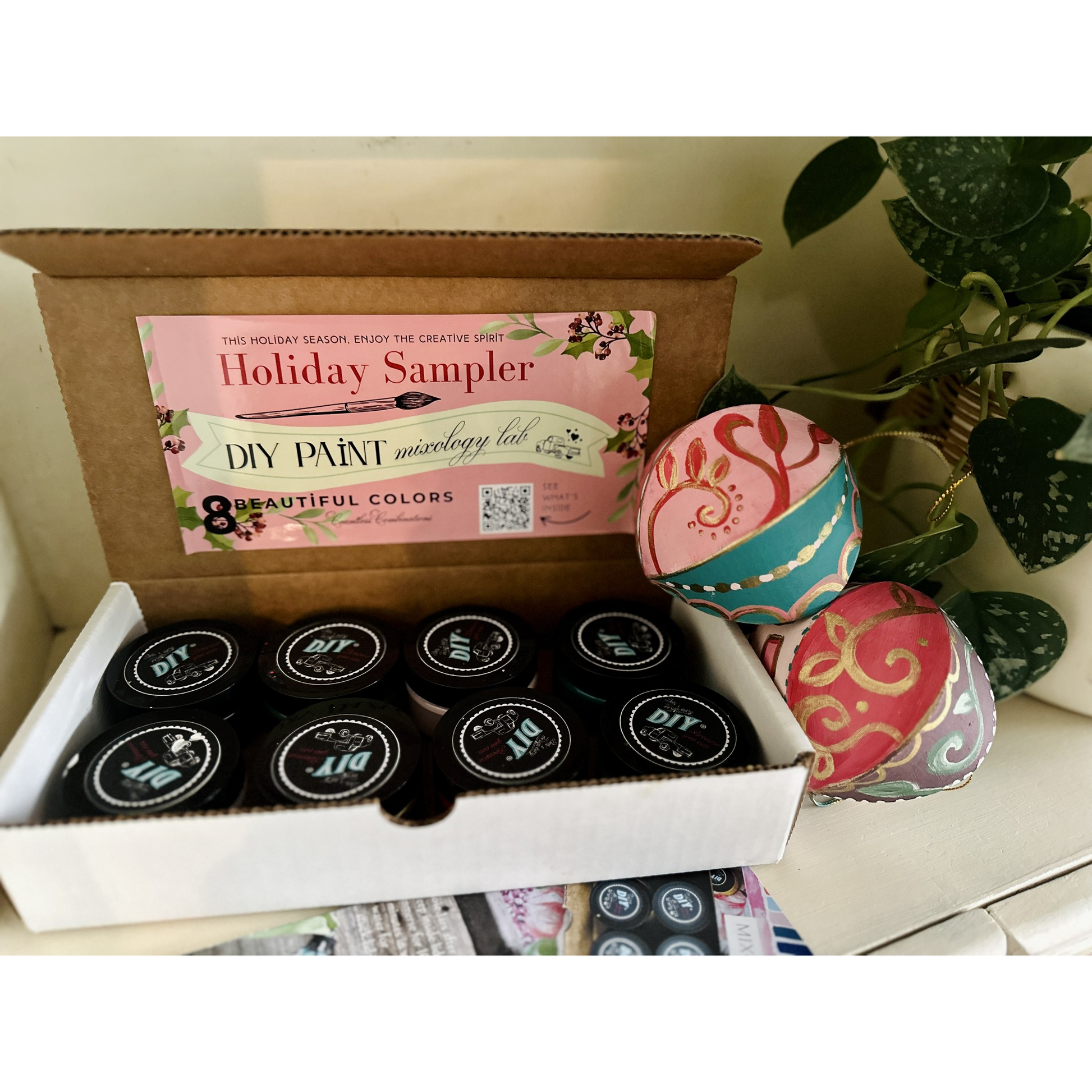 Holiday Sampler DIY paint set with decorative containers on a white surface.