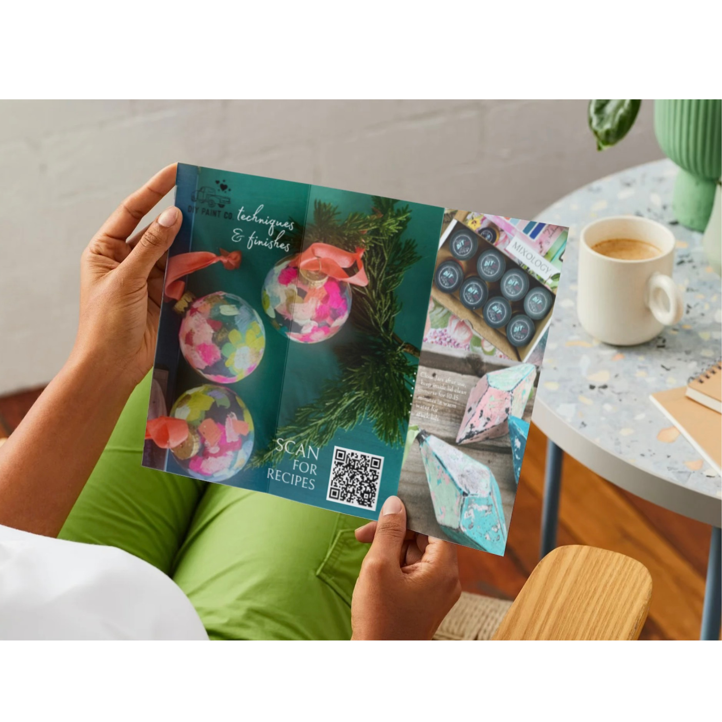 Person holding a brochure with a QR code on a casual setting.