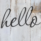 Example of Swoosh stamp applied with black ink to white distressed wood plank board.  Reads, "Hello," at Milton's Daughter.